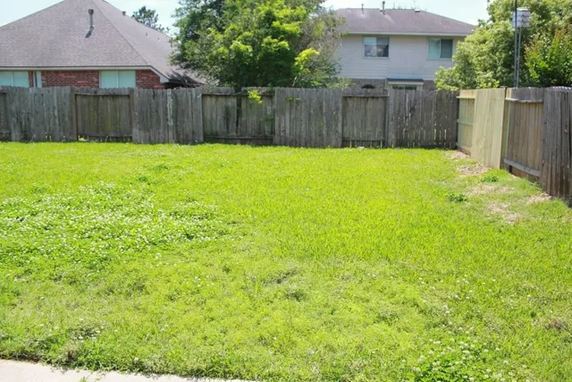 a view of a backyard with wooden fence