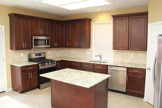 a kitchen with granite countertop wooden cabinets and stainless steel appliances