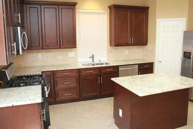 a kitchen with a sink a stove and cabinets