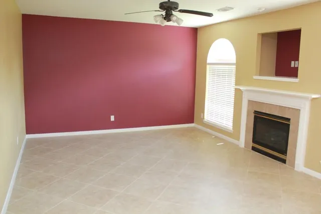a view of empty room with a fireplace and fan