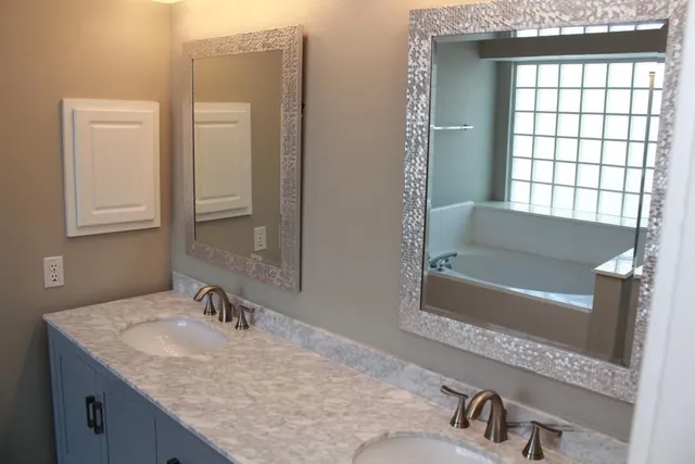 a bathroom with a granite countertop sink and a bathtub