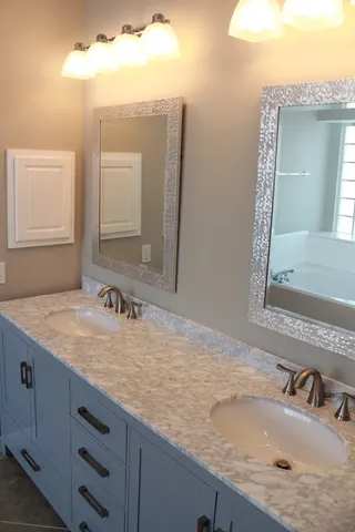 a bathroom with a granite countertop sink and a mirror