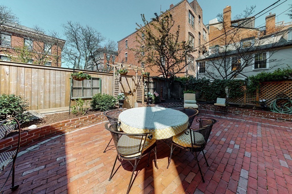 23 Pinckney Street, Unit 1 Boston, MA 02114 - Photo 5 of 17 a backyard of a house with table and chairs