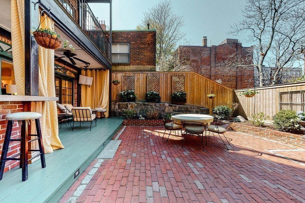 23 Pinckney Street, Unit 1 Boston, MA 02114 - Photo 7 of 17 a backyard of a house with barbeque oven table and chairs
