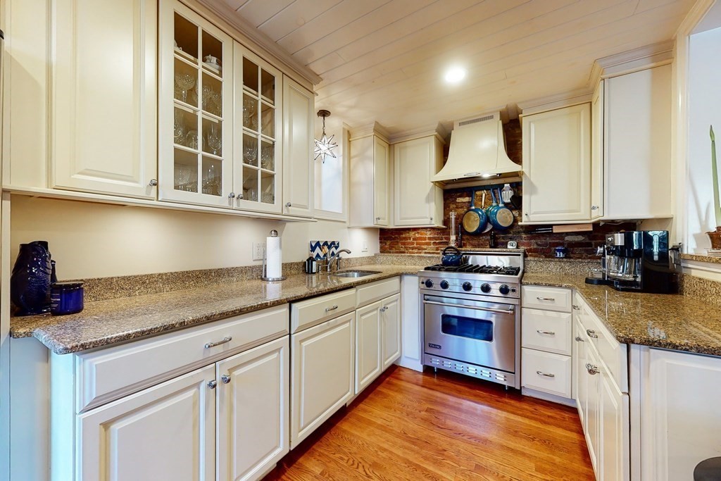 23 Pinckney Street, Unit 1 Boston, MA 02114 - Photo 9 of 17 a kitchen with stainless steel appliances granite countertop a stove and a sink