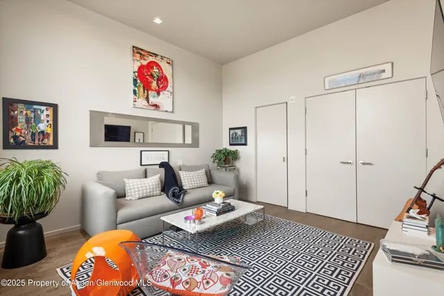 a living room with furniture a rug and a painting on the wall