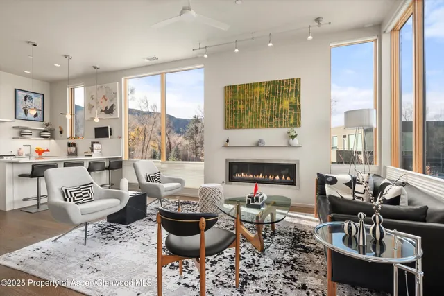 a living room with furniture fireplace and a large window