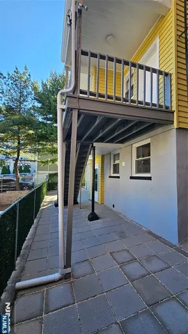 a view of house with a large window and potted plants
