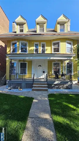 a front view of building with outdoor seating and yard