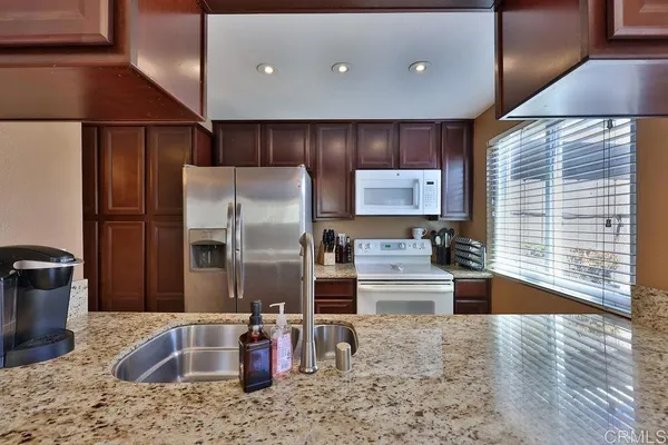 a kitchen with stainless steel appliances granite countertop a refrigerator and a sink