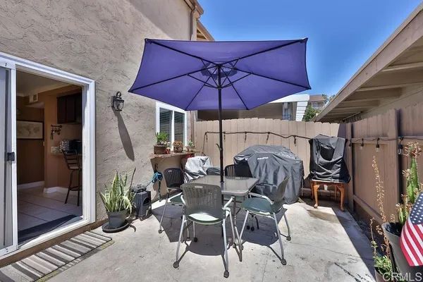 a view of a patio with table and chairs under an umbrella