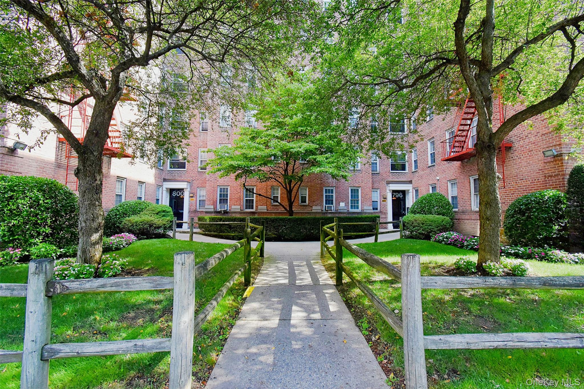 a front view of a house with yard and large trees