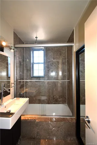 a bathroom with a granite countertop sink a bathtub and shower