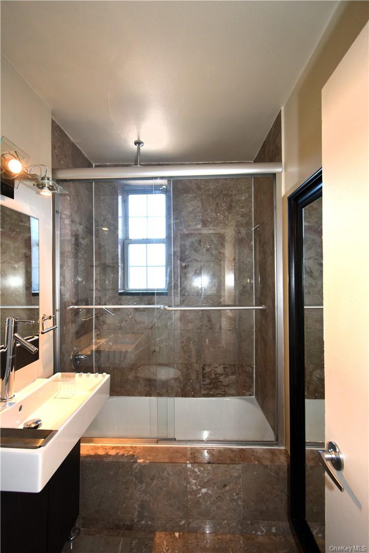 796 Bronx River Road, Unit B38 Bronxville, NY 10708 - Photo 16 of 21 a bathroom with a granite countertop sink a bathtub and shower