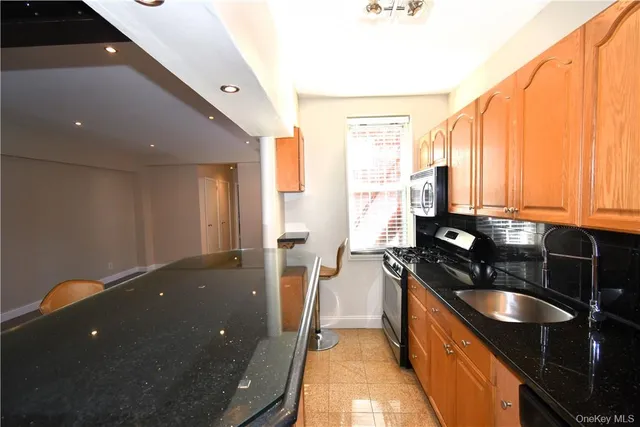 a kitchen with granite countertop sink stove and cabinets