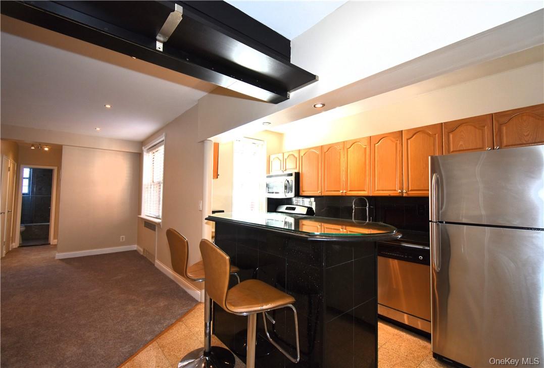 796 Bronx River Road, Unit B38 Bronxville, NY 10708 - Photo 6 of 21 a kitchen with a sink a refrigerator and chairs
