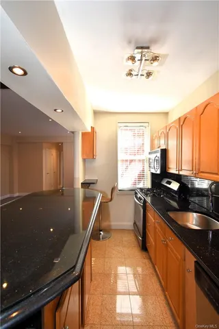 a kitchen with granite countertop sink stove and cabinets