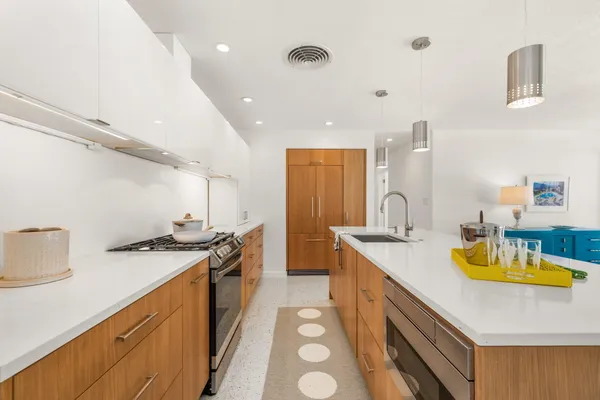 a kitchen with a sink a stove and chairs