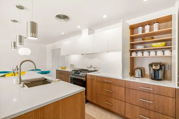 a kitchen with a sink a stove and cabinets