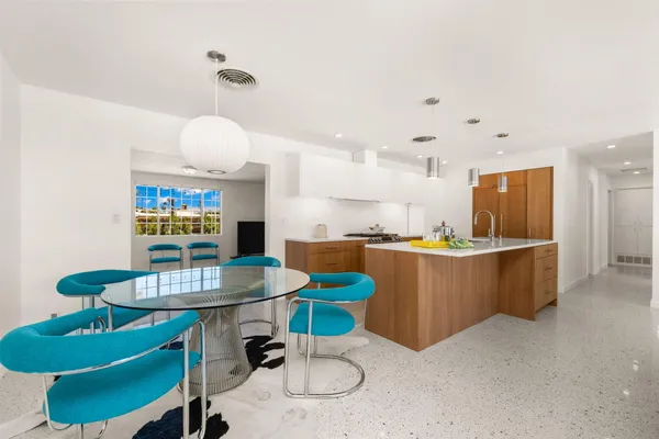 a kitchen with a dining table cabinets and stainless steel appliances