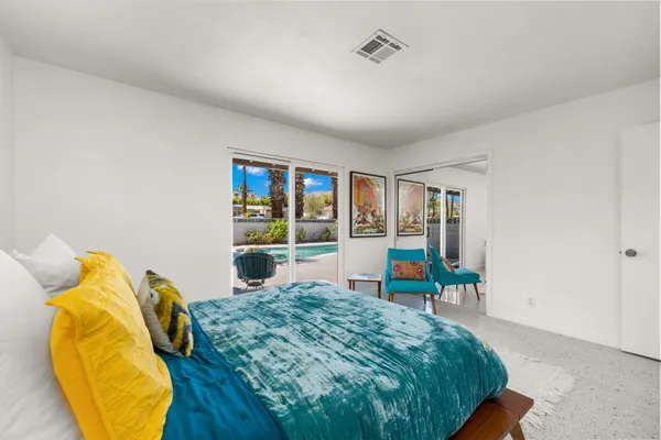 a bedroom with a bed and large windows