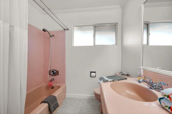 a bathroom with a sink and mirror with bathtub