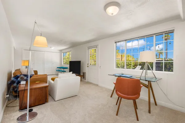a living room with furniture a window and a chandelier