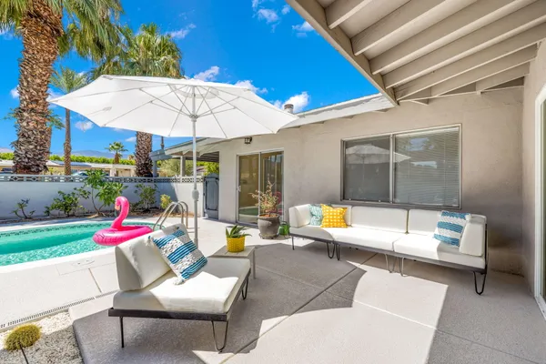 a patio with a table and chairs under an umbrella