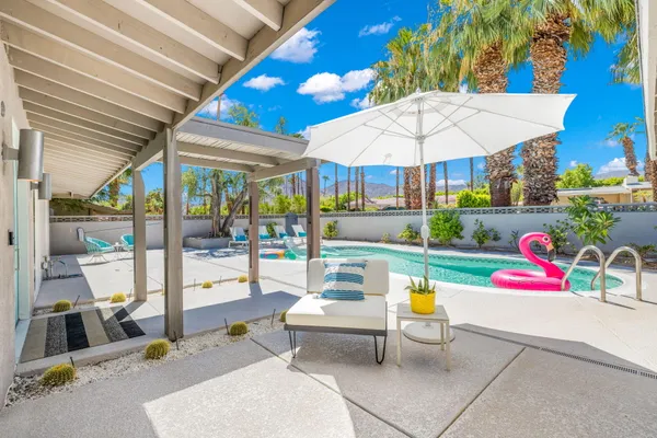 a view of a patio with a table and chairs under an umbrella