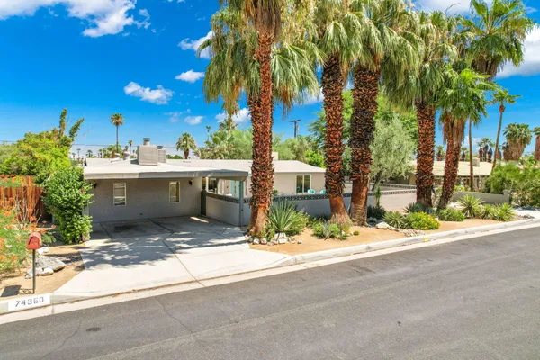 a view of house with palm trees