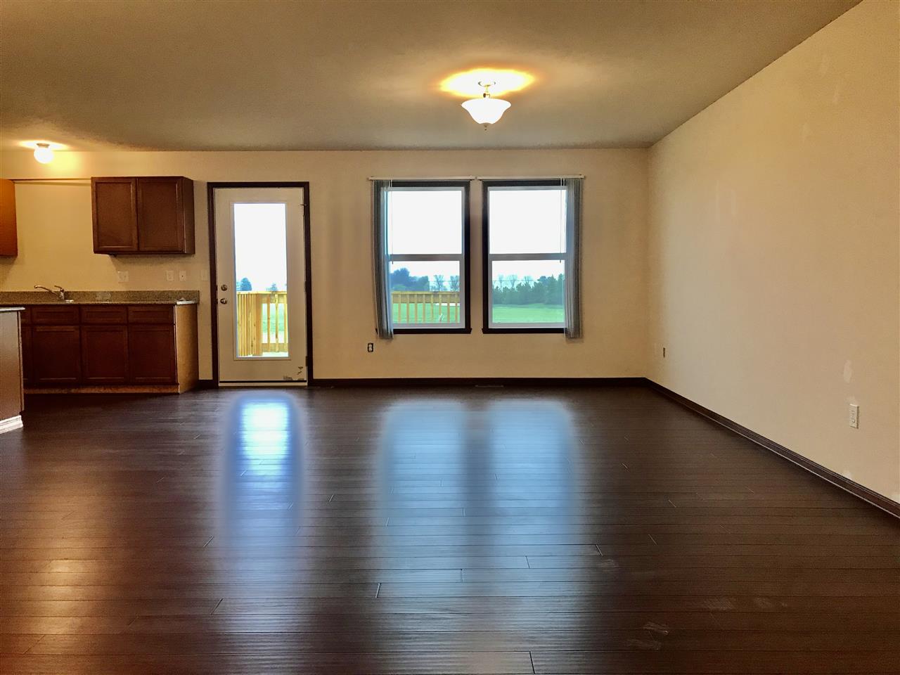 6915 Winterberry Road Loves Park, IL 61111 - Photo 4 of 15 an empty room with wooden floor and windows