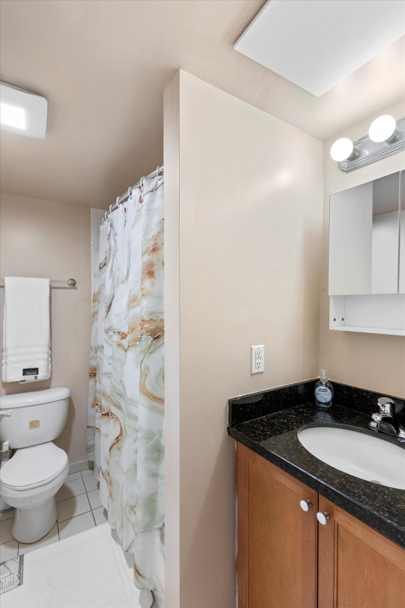 201 Coppitt Road, Unit 104C Key West, FL 33040 - Photo 12 of 18 a bathroom with a granite countertop sink a toilet and shower