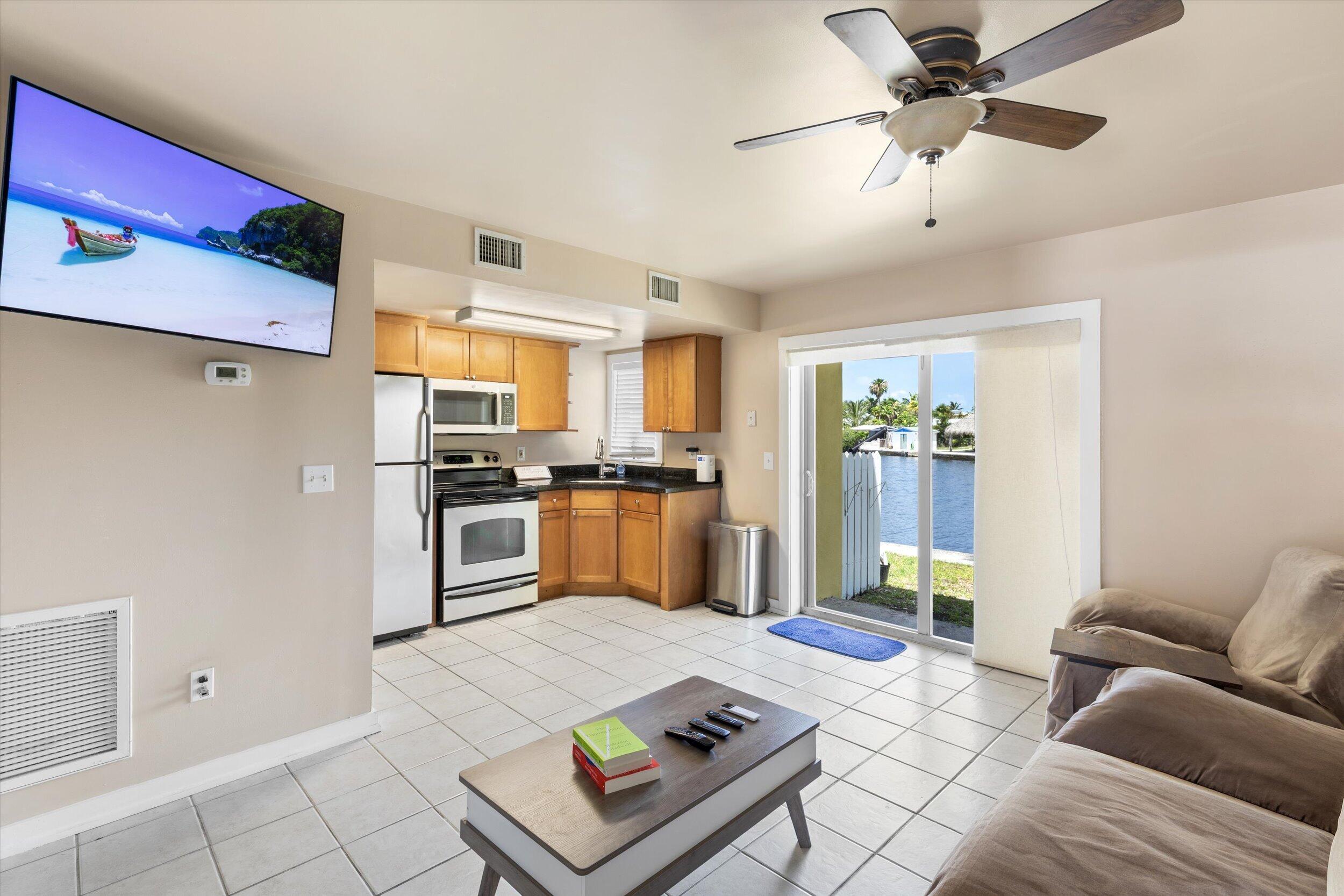 201 Coppitt Road, Unit 104C Key West, FL 33040 - Photo 2 of 18 a kitchen with a refrigerator a stove cabinets and living room view