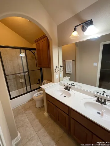 a bathroom with a double vanity sink toilet and mirror