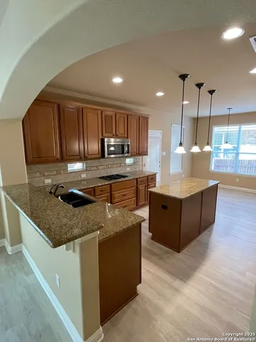 a kitchen with stainless steel appliances granite countertop a stove a sink a oven and a refrigerator