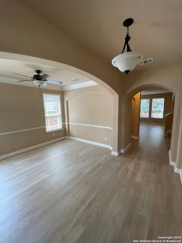 a view of an empty room with window and wooden floor