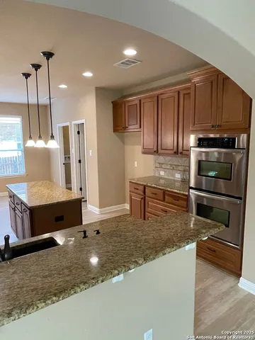 a kitchen with stainless steel appliances granite countertop a stove a sink and a microwave with granite countertops