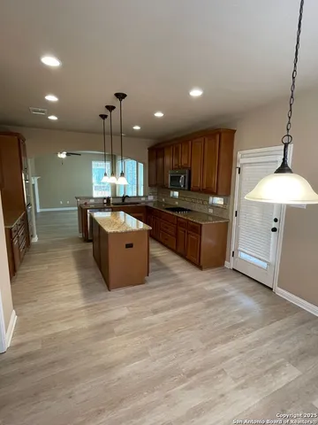 a large kitchen with stainless steel appliances granite countertop a stove oven and a refrigerator