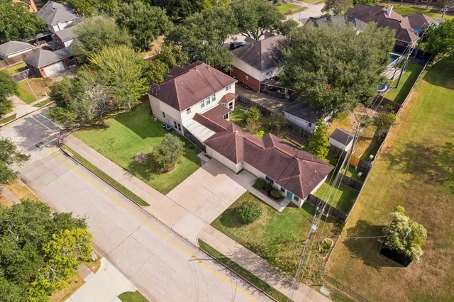 an aerial view of a house with a yard and trees