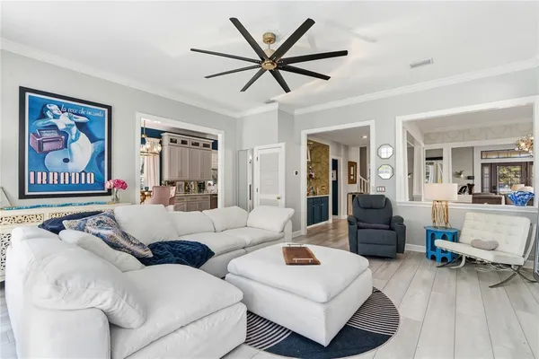 a kitchen with stainless steel appliances kitchen island granite countertop dining table chairs and a refrigerator