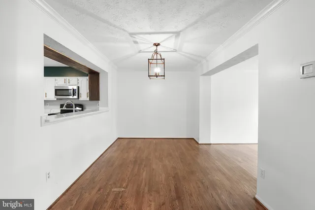 a view of a kitchen with wooden floor and a ceiling fan