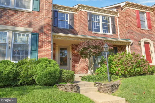 front view of a brick house with a yard