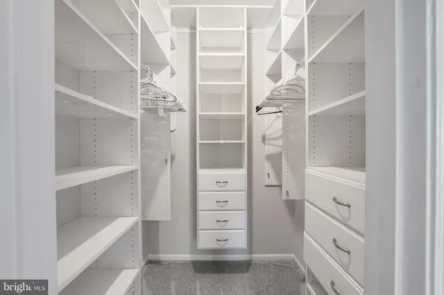 a view of walk in closet with empty racks