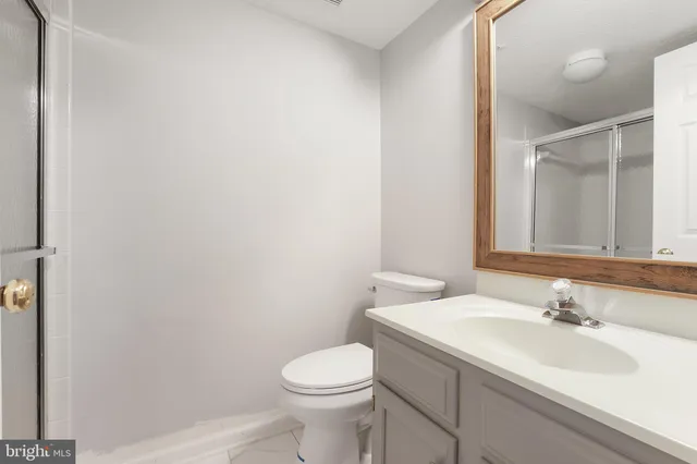 a bathroom with a sink toilet and a mirror
