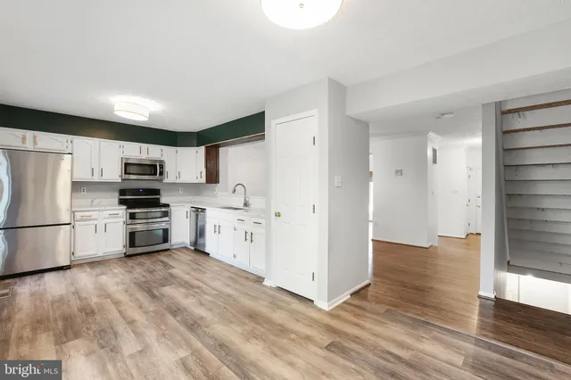 a kitchen with stainless steel appliances and white cabinets