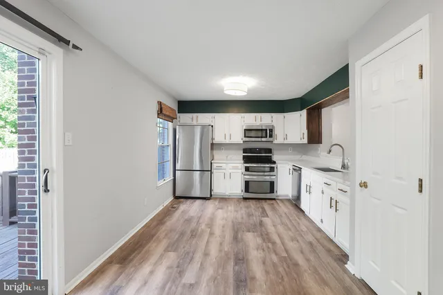 a kitchen with stainless steel appliances a refrigerator and a stove top oven