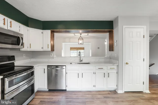 a kitchen with stainless steel appliances granite countertop a stove a sink and a microwave