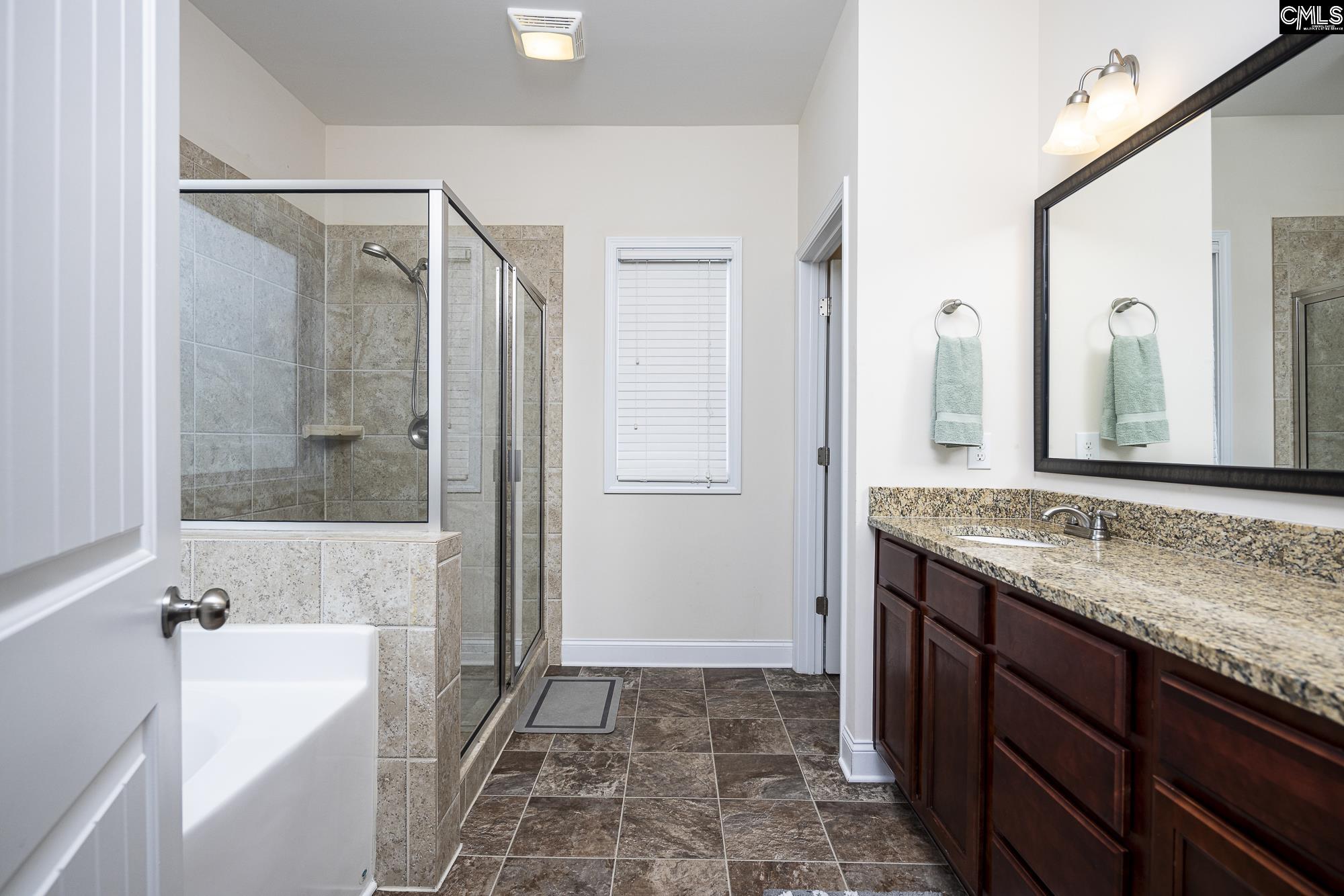213 Sunset Point Drive Lexington, SC 29072 - Photo 21 of 35 a bathroom with a granite countertop bathtub shower sink and mirror