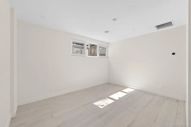 a view of an empty room with chandelier fan