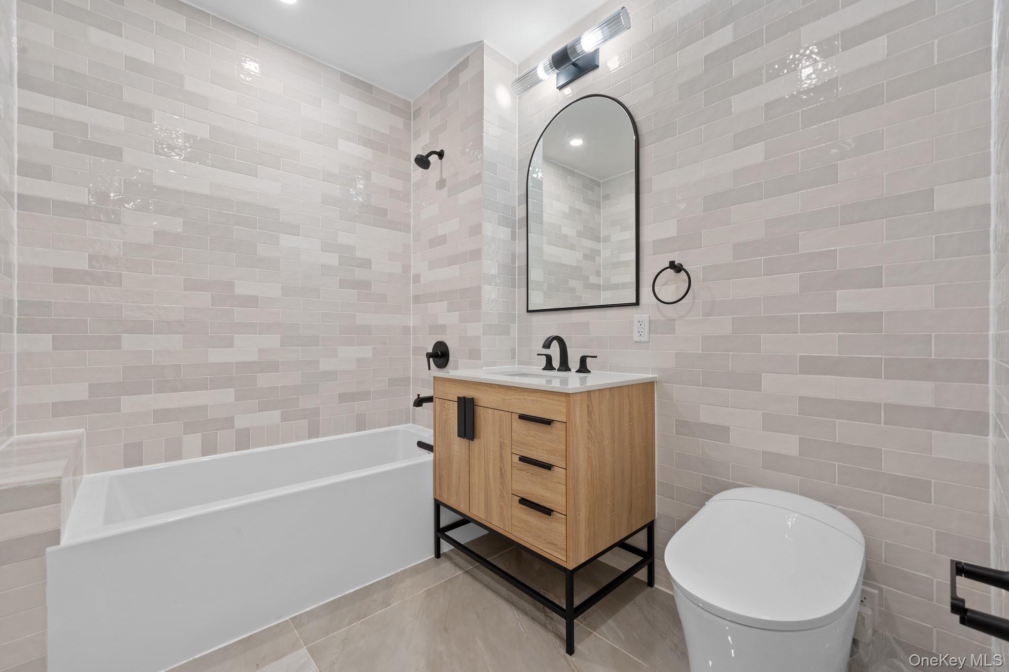 310 Fenimore Street, Unit 1 Brooklyn, NY 11225 - Photo 3 of 15 a bathroom with a sink a toilet and a bathtub